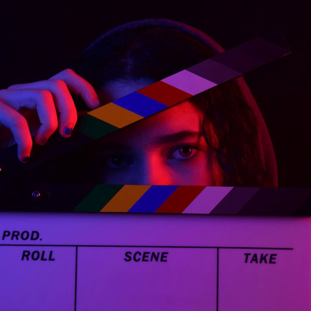 Woman with film clap in the dark.