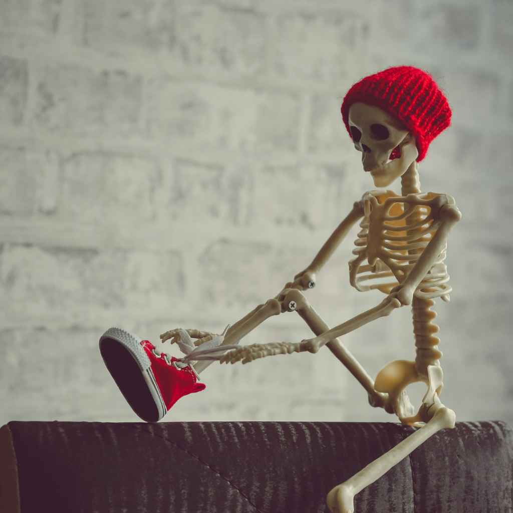 A skeleton tying a shoe.