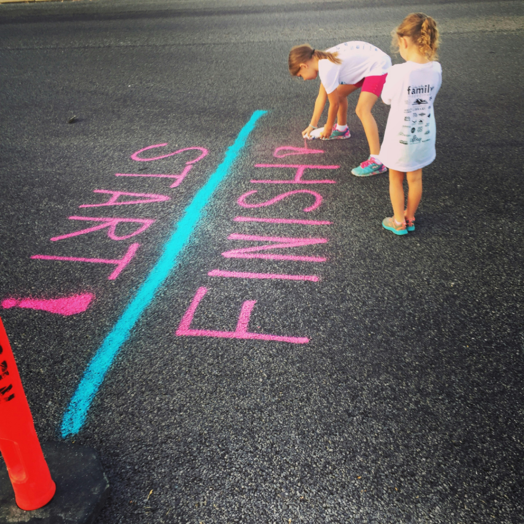 Children drawing a start and finish line next to each other.