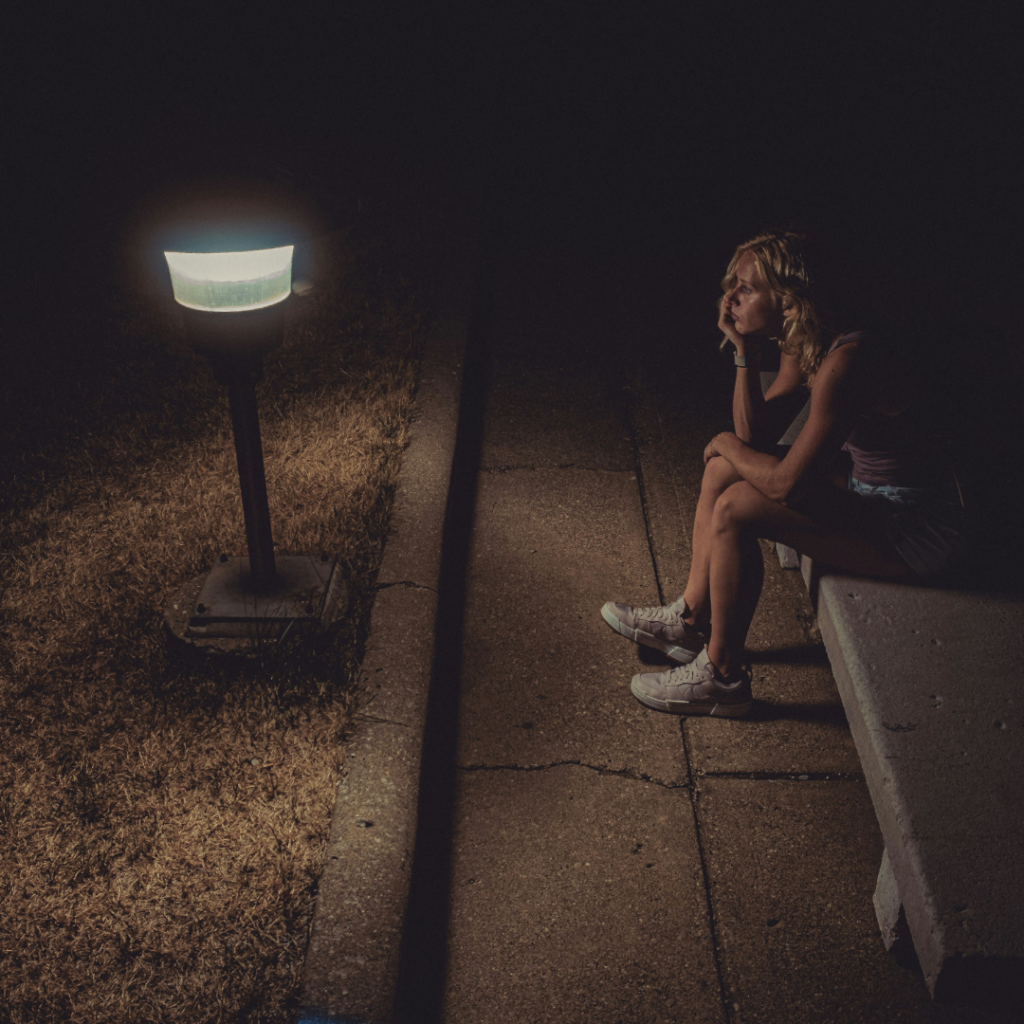 Woman dealing with loss on a bench at night