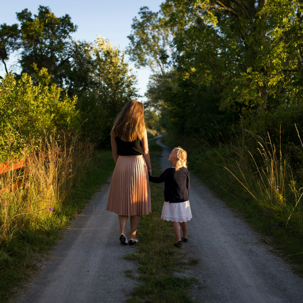 Mother and Daughter walking on a country road.