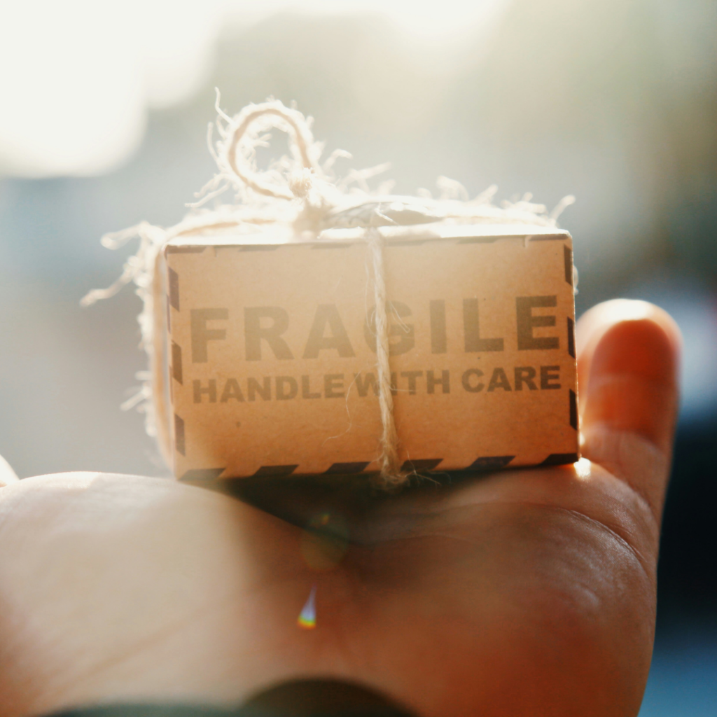 Person holding a parcel named fragile. How to deal with criticism and how to give it.