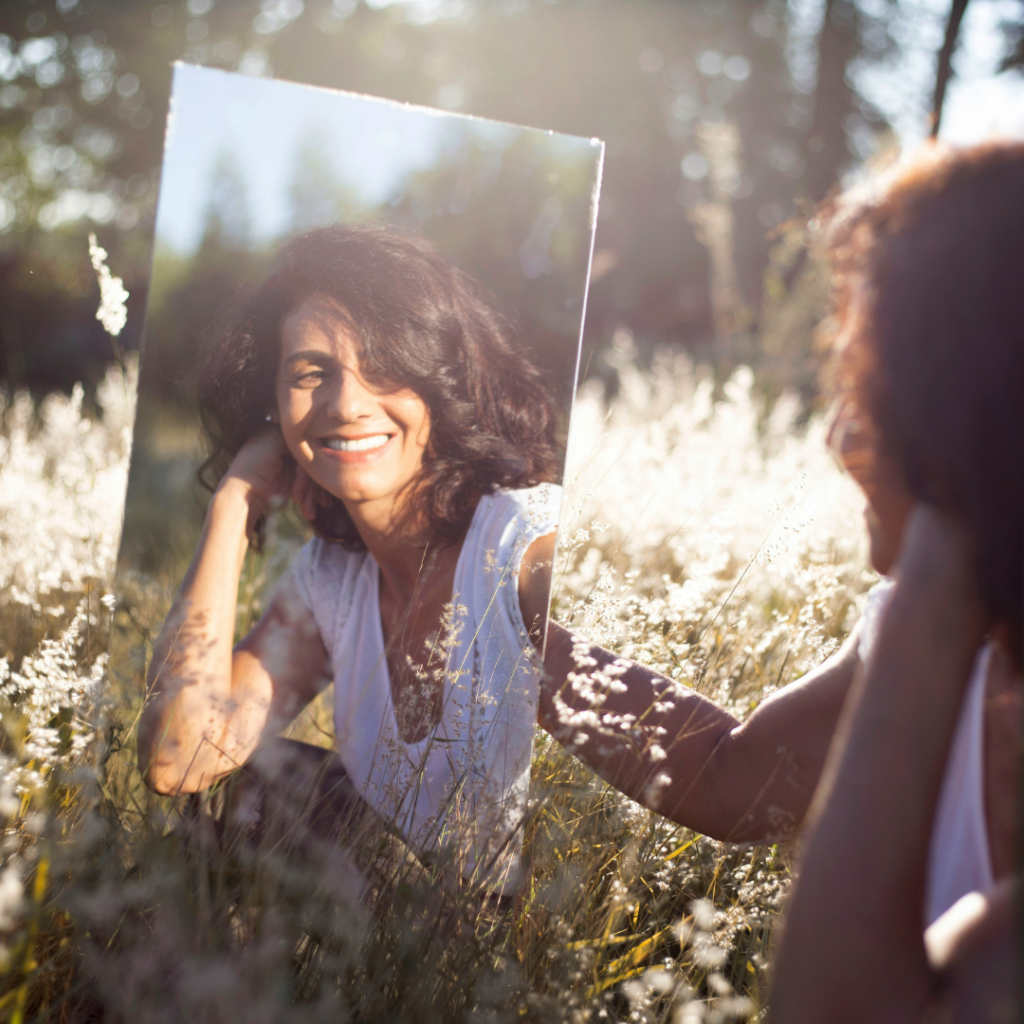 Mirror showing reflection of a woman in the fields.