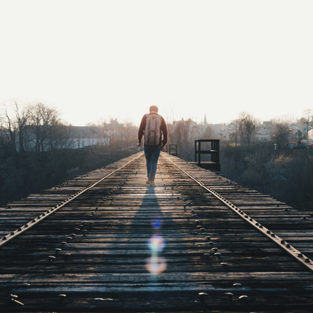 A person walking on the train tracks alone.
