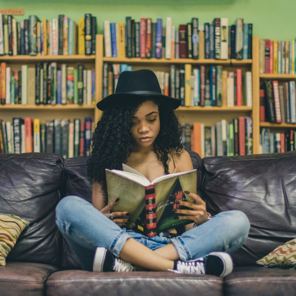 Woman sitting on a sofa reading a book.