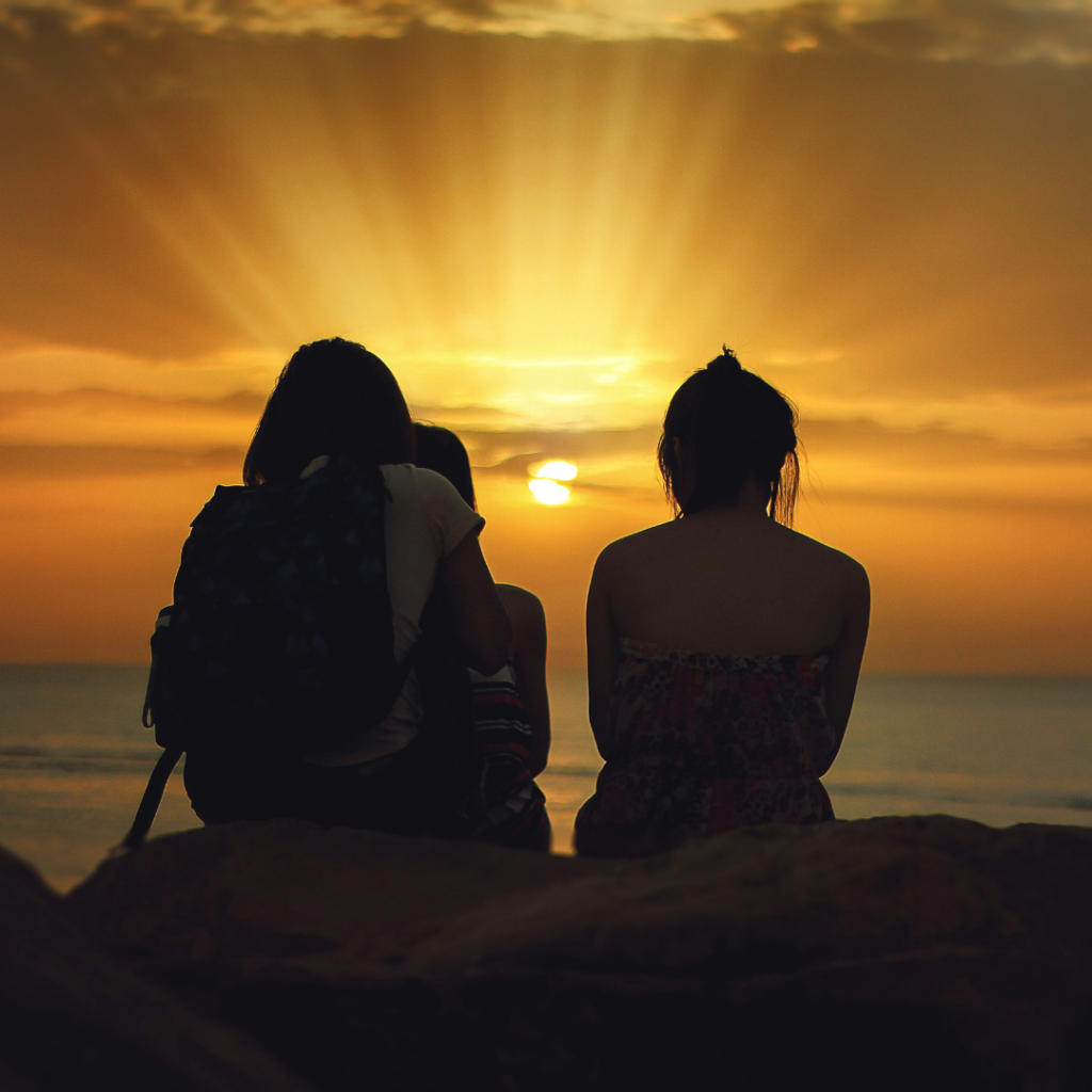 Friends looking at the sunset living in the moment.