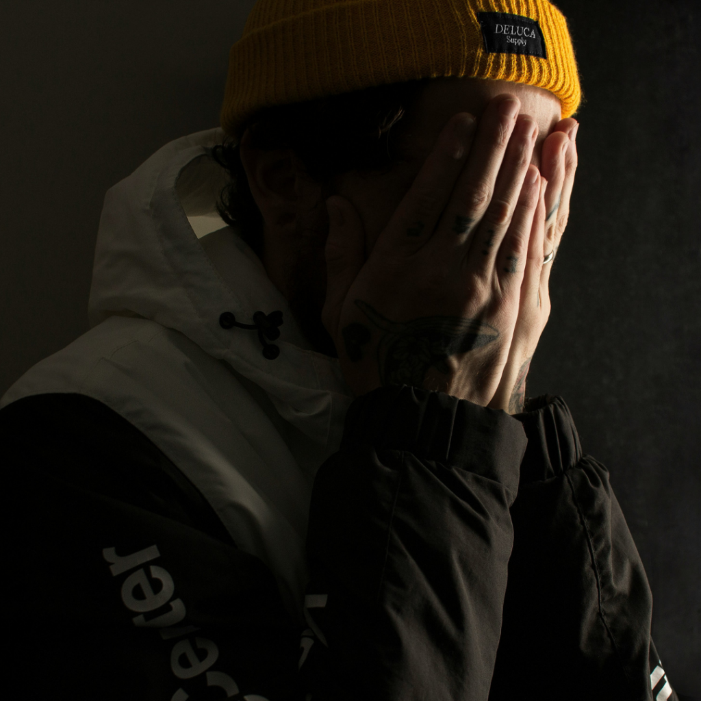 Man covers his face in shame.