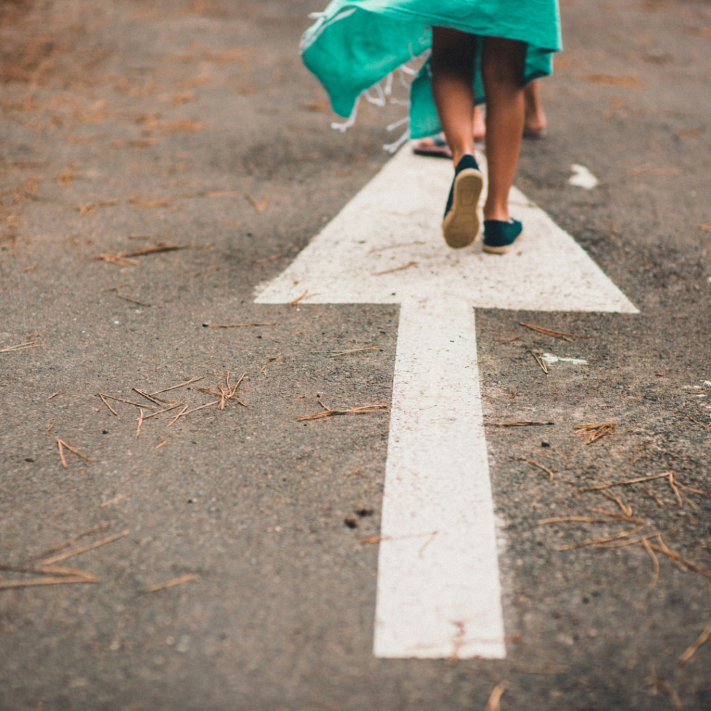 Woman walking on an arrow pointing to move forward.