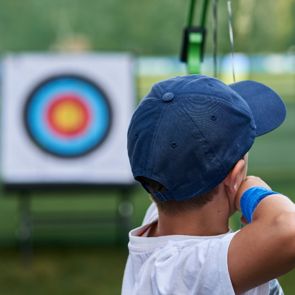 Young archer aim at his target.