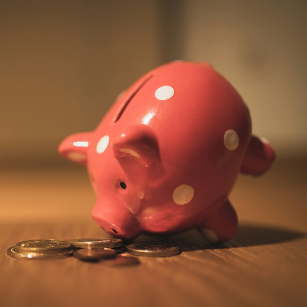 Piggy bank smelling coins on a table.