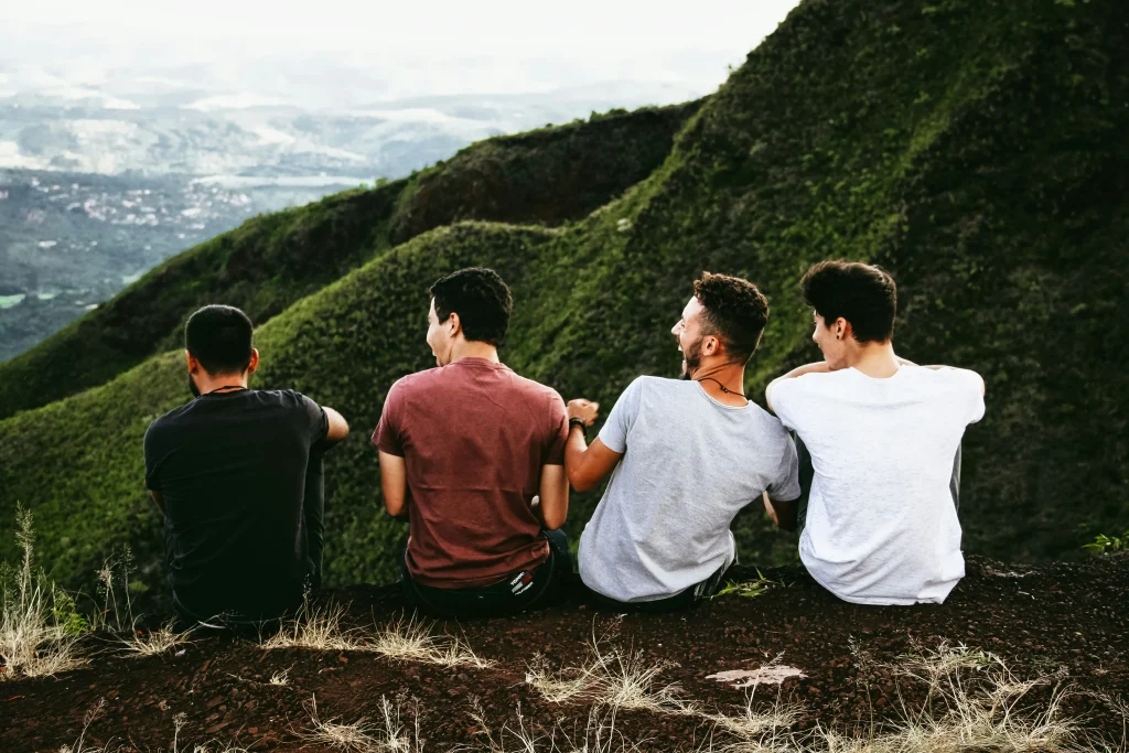 Group of men sitting on a hill.
